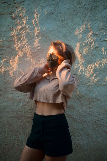 A beautiful girl with a mask by a wall