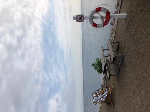 A closeup of a lifeline on the coastline near a table and a bench