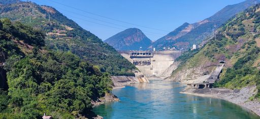 A natural view of a dam and mountain landscape under clear sky