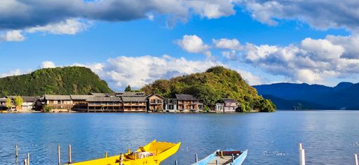 A natural view of a small village in the middle of a calm lake under a cloudy sky