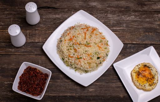 A top view of delicious rice with carrot and other tasty meals on the wooden table