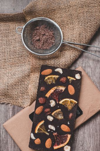 A vertical shot of a chocolate bar with nuts and dried fruit