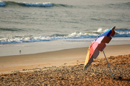 A colorful beach umbrella on a sandy coast