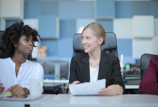 A successful female team leader in a formal outfit presenting the new business project to her partners in a modern startup office