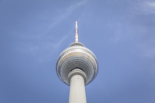 A low angle shot of a white tower under the beautiful blue sky