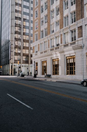 A vertical shot of the empty road with tall buildings.