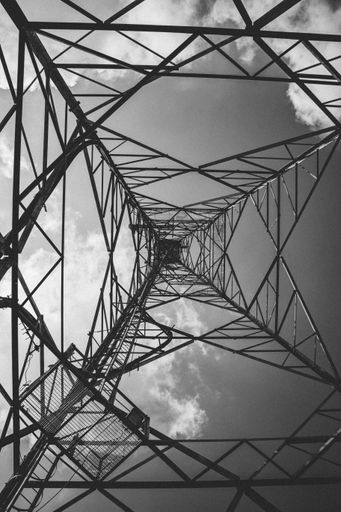 A grayscale shot inside an electricity transmission tower