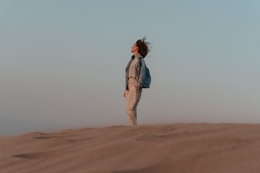 Desert adventure. Young woman  walking on sand dunes, windy weather. Patara sand dunes, Turkey