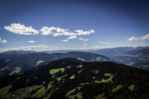 A beautiful high angle scenic shot of green mountains under the blue cloudy sky