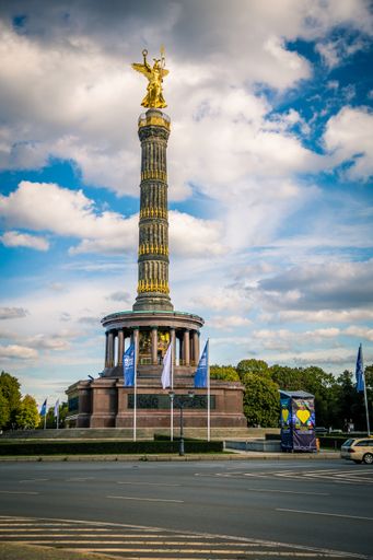 A vertical shot of the Victory Column Monument in Berlin against blue cloudy sky