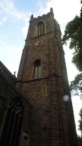 A vertical low angle shot of a tower with a clock
