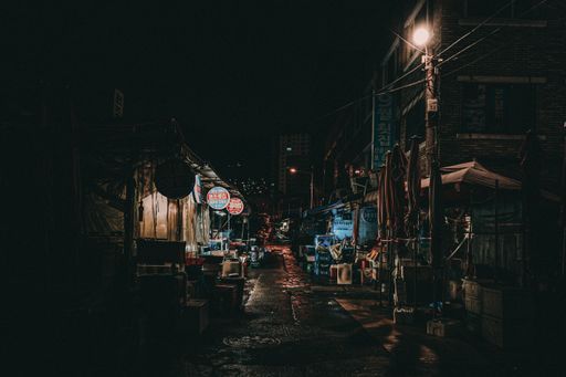 A dark scene of a street in an Asian market at night