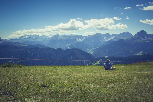 A lonely male relaxing and admiring the beautiful view of mountains under the cloudy sky