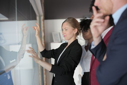 A successful female team leader in a formal outfit presenting the new business project to her multiethnic partners in a modern startup office