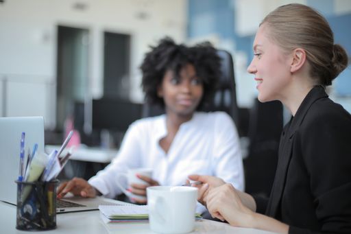 A successful female team leader in a formal outfit presenting the new business project to her partners in a modern startup office
