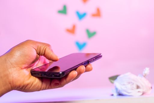 A hand of a man sending love text message - online dating concept