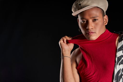 The studio portrait of a latin man with beret on black background