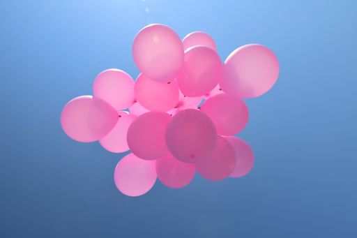 A closeup of pink balloons in the sky