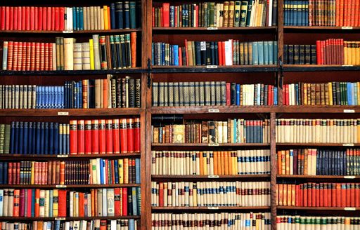 A picture of bookcase with many colorful books in the library