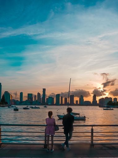 A vertical shot of a boy and girl fishing under a cloudy sky in sunset