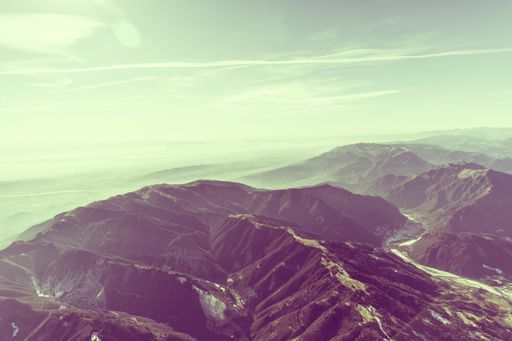 A high angle shot of beautiful high mountains covered in snow under the breathtaking blue sky