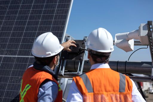 A closeup shot of engineers working on the solar panel