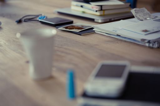 A workspace desk with documents and notepads on a blurred background