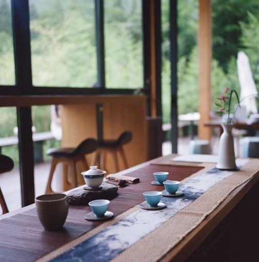 A vertical shot of a tea set on a wooden table in a vintage composition