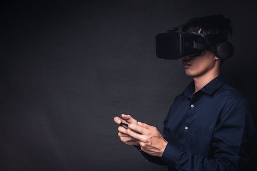 A young gamer wearing VR head-mounted and using online technology