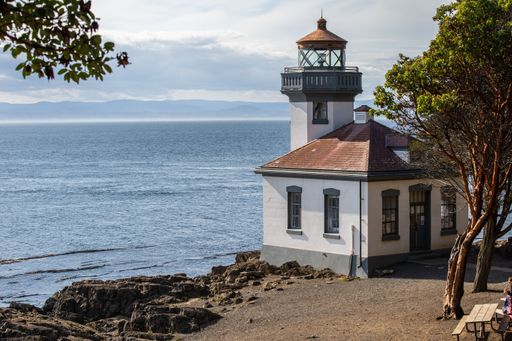 The Lime Kiln Lighthouse surrounded by the water under a cloudy sky in Washington State