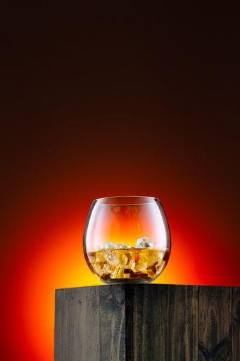 A beautiful shot of a glass of whiskey on a wooden table