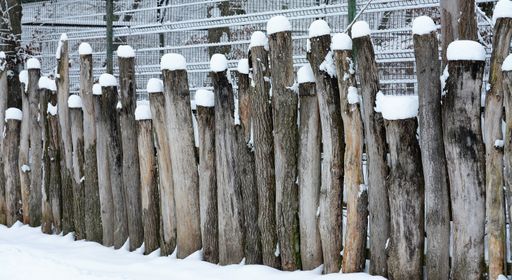 A beautiful shot of a wooden fence covered with snow
