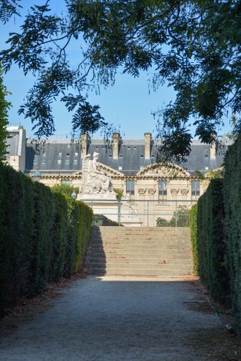 The staircases of a building surrounded by trees under the blue sky
