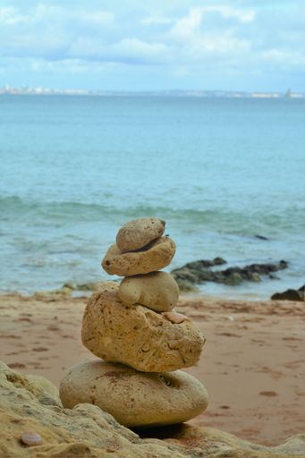 A vertical shot of pebbles on the beach balanced perfectly on top of each other