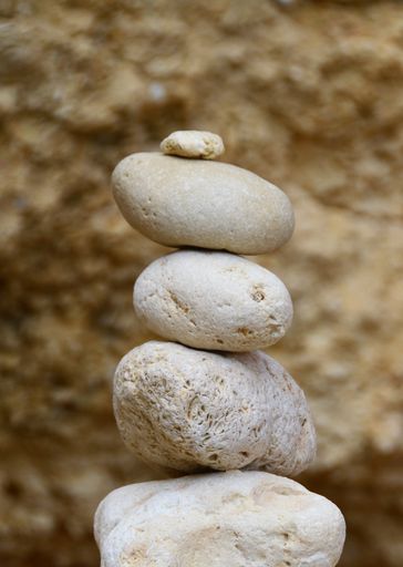 A vertical closeup shot of white pebbles balanced on top of each other