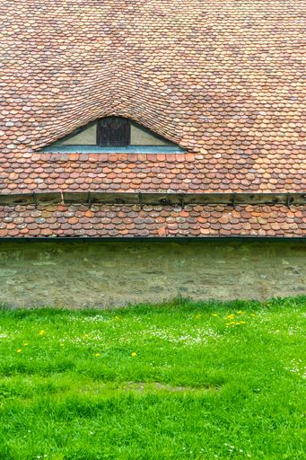 A vertical shot of an old house roof near grass in Rothenburg ob der Tauber, Germany