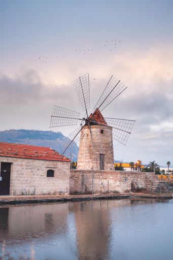 A beautiful landscape view of The salt pans of Trapani Windmill at sunset in Italy