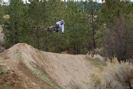 A scenic shot of a biker doing cool tricks in the mountains
