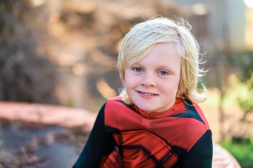 An adorable young Caucasian boy with blonde hair smiling