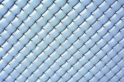 diamond-shaped wire fence covered with snow