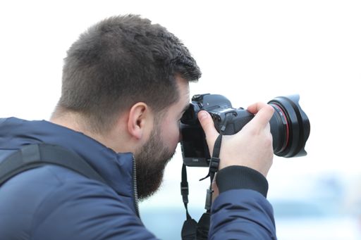 A male photographer using a professional camera outdoors