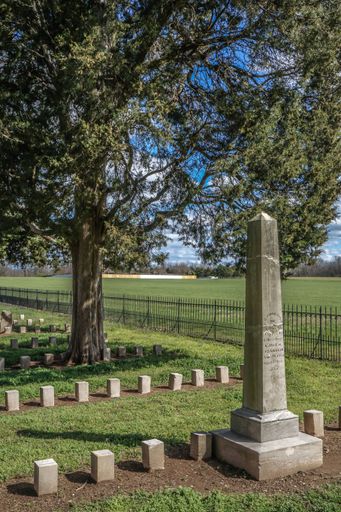 A vertical shot of a cemetery with beautiful green field next to it