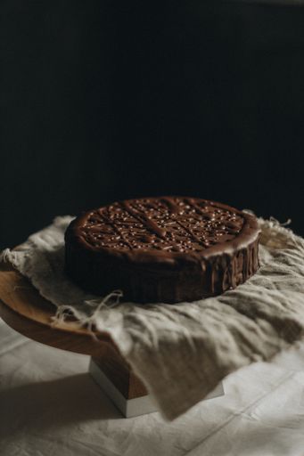 A vertical selective closeup shot of chocolate cake on a fabric on a round table