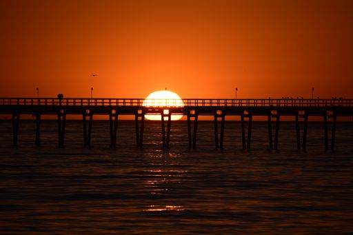 A pier over the Pacific Ocean during a breathtaking sunset in Goleta, California