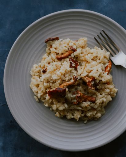 A vertical closeup shot of cooked rice with meat on a gray ceramic plate