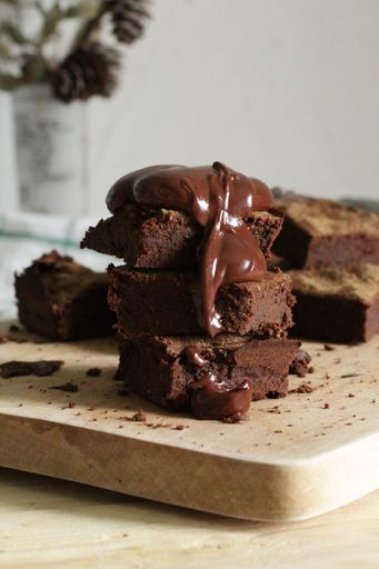 A vertical selective closeup shot of stacked chocolate brownies on a chopping board