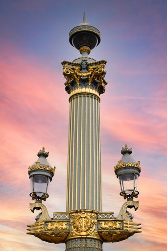 A beautiful and monumental ornate column with lanterns in the Place de la Concorde in Paris, France