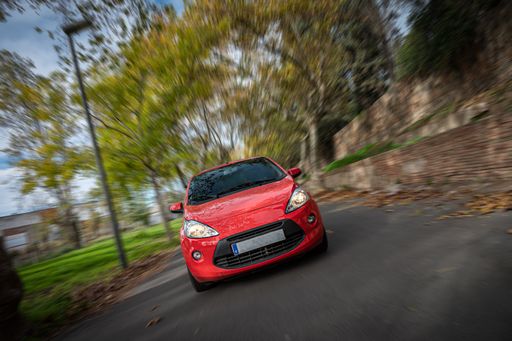 A front view of a small red Ford Ka car outdoors