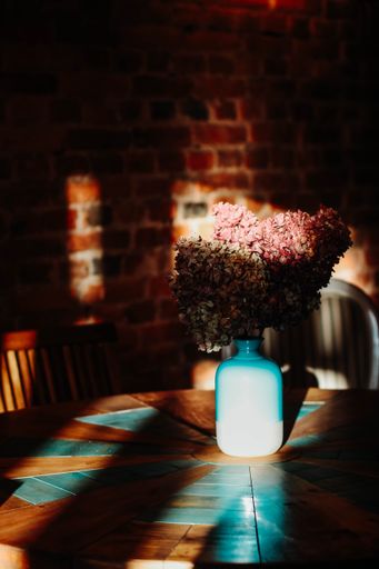 A vertical selective shot of flowers in a blue vase on a table