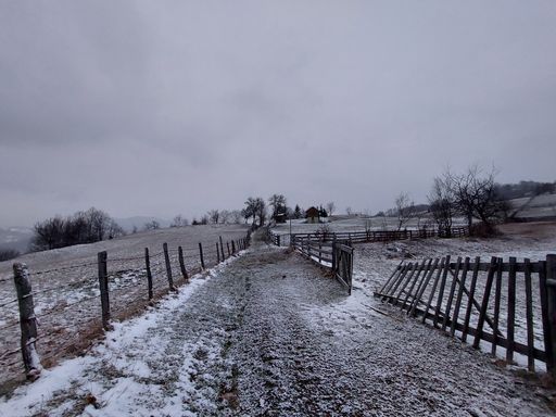 A snow covered country road in the village in a freezing winter